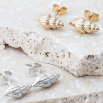 A pair of gold and a pair of silver shell studs.